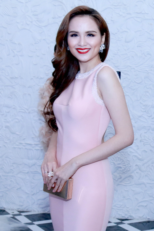 Hoa hậu Thế giới người Việt 2010 chọn váy hồng pastel, tô son đỏ nổi bật cùng mái tóc uốn bồng bềnh.