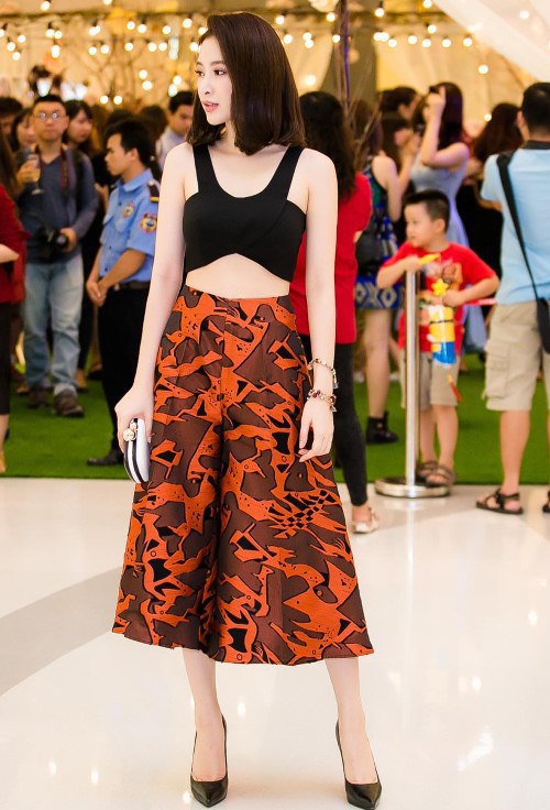 Phương Trinh toát lên nét đẹp năng động với áo crop-top đen và quần lửng ống loe họa tiết.